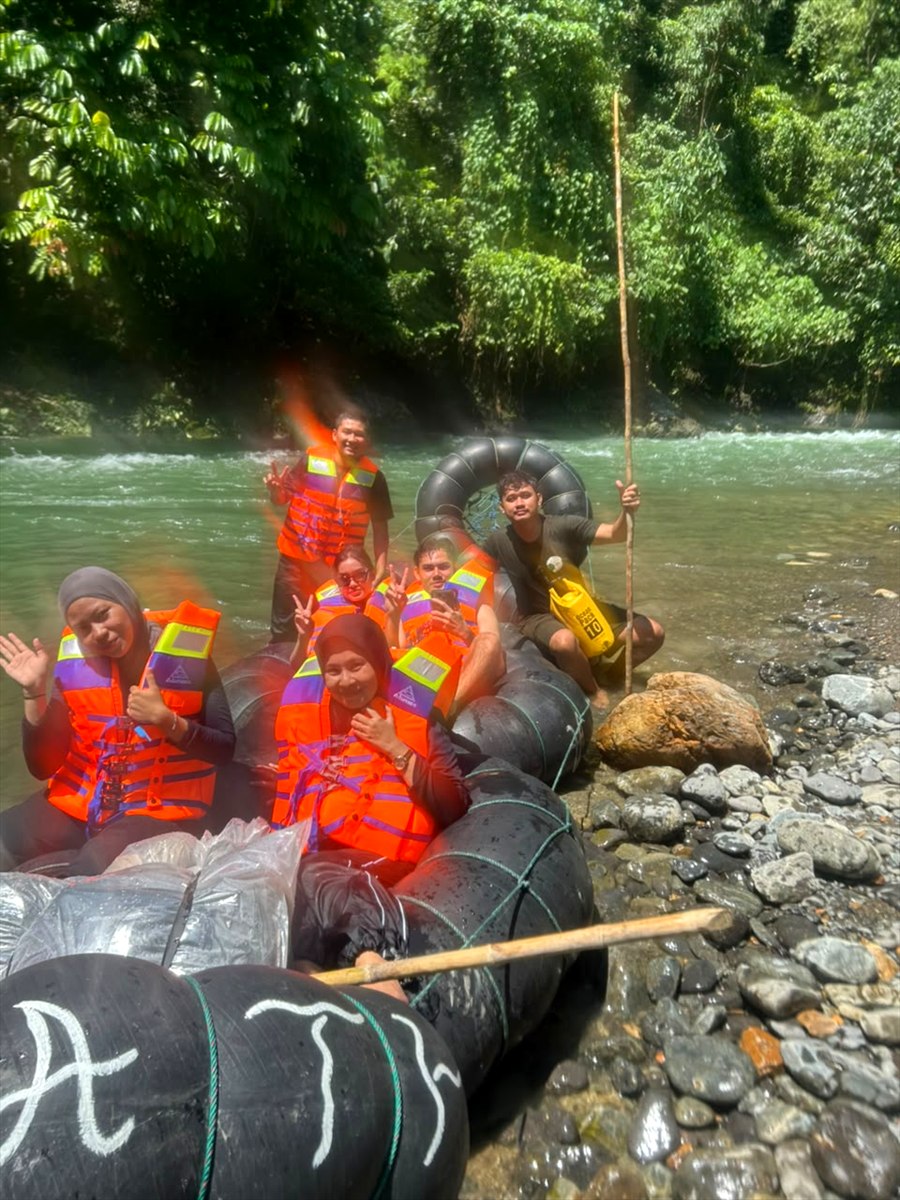 Peserta menikmati aktivitas air dengan ban di sungai